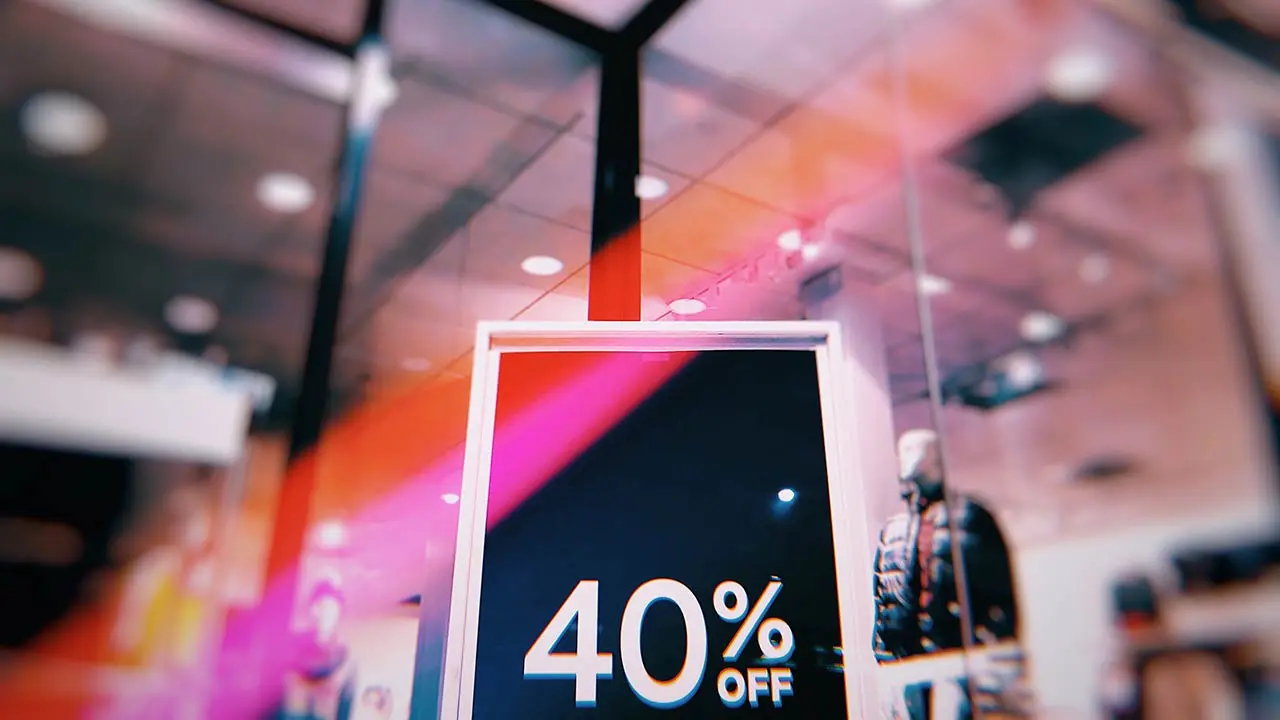 Cliente observando cartelería en retail con marco de aluminio