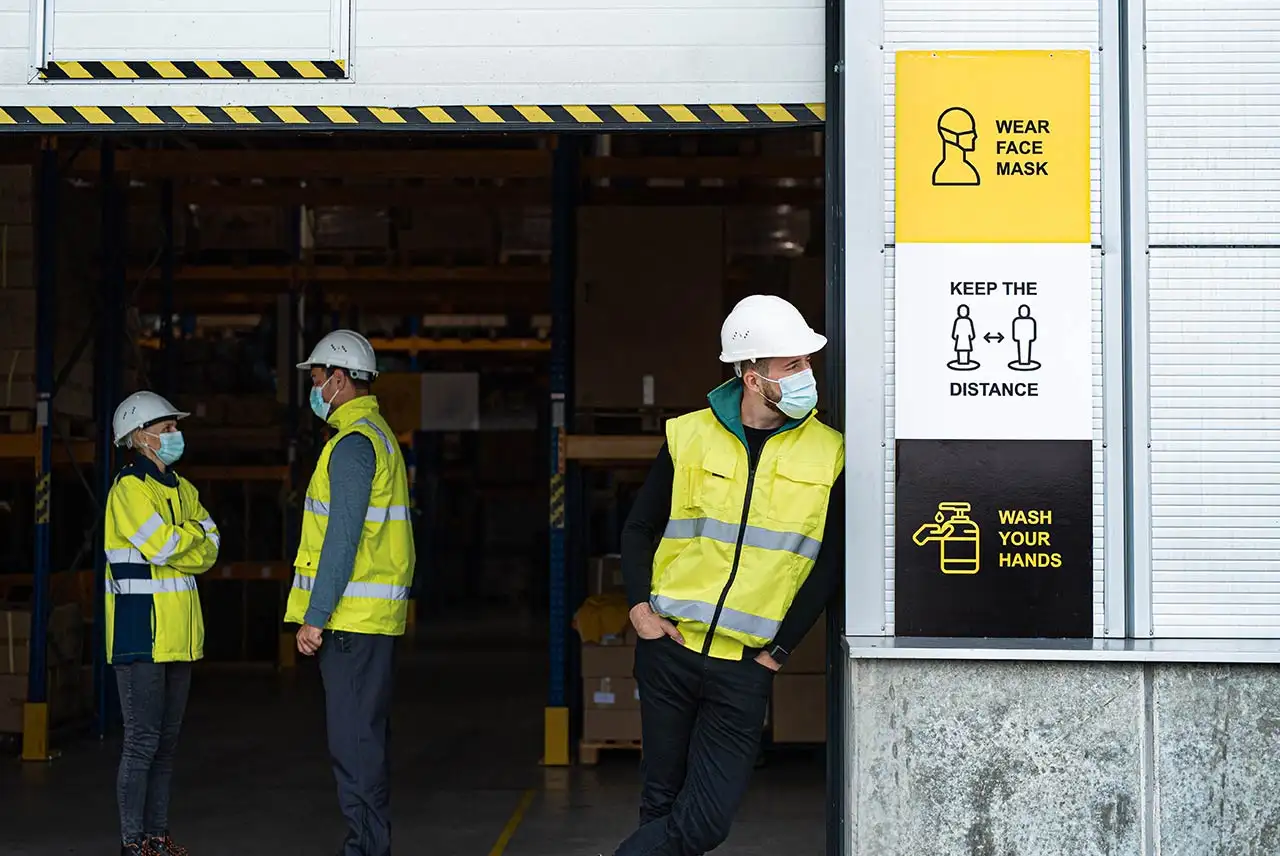 Pasillo peatonal señalizado con pintura amarilla y barreras de protección flexibles junto a zona de carretillas.