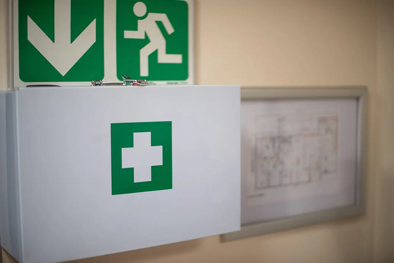 Señal de salida de emergencia fotoluminiscente instalada en el pasillo de un centro educativo conforme a la normativa UNE.