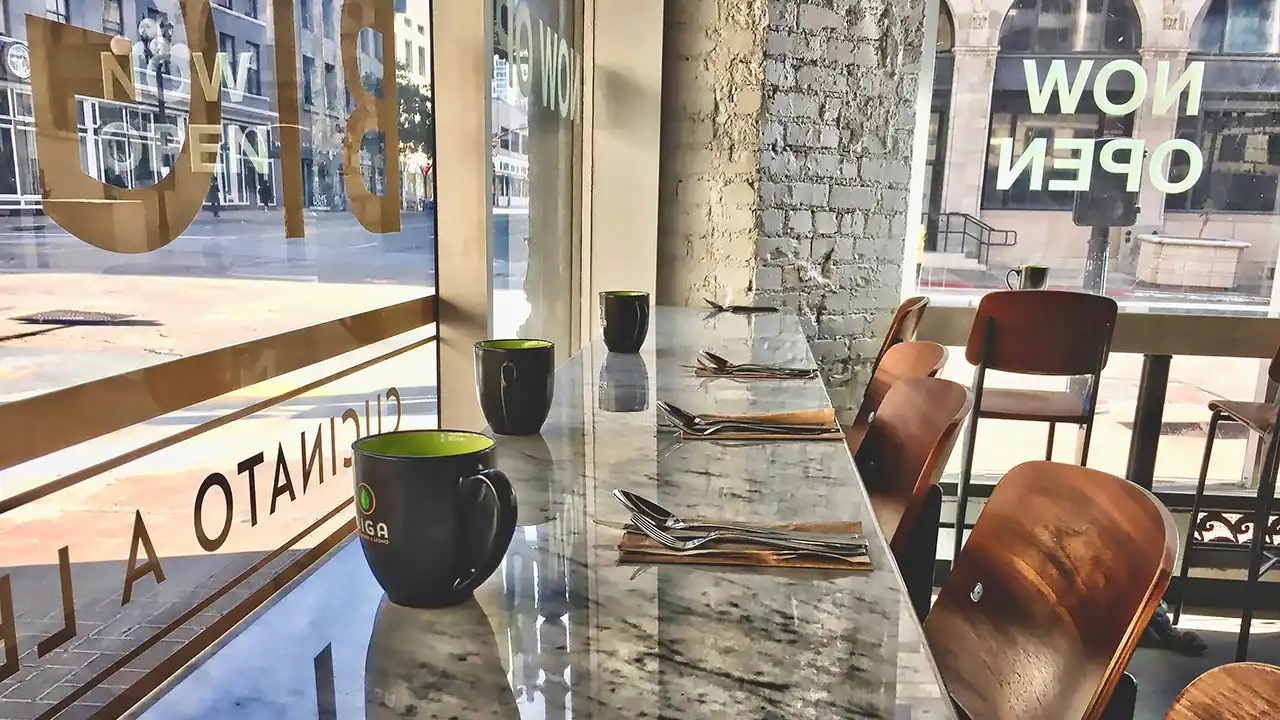 Interior de un restaurante de franquicia moderna mostrando la integración de marca mediante menús rígidos, rótulos luminosos y decoración HORECA coordinada por Vatisa.