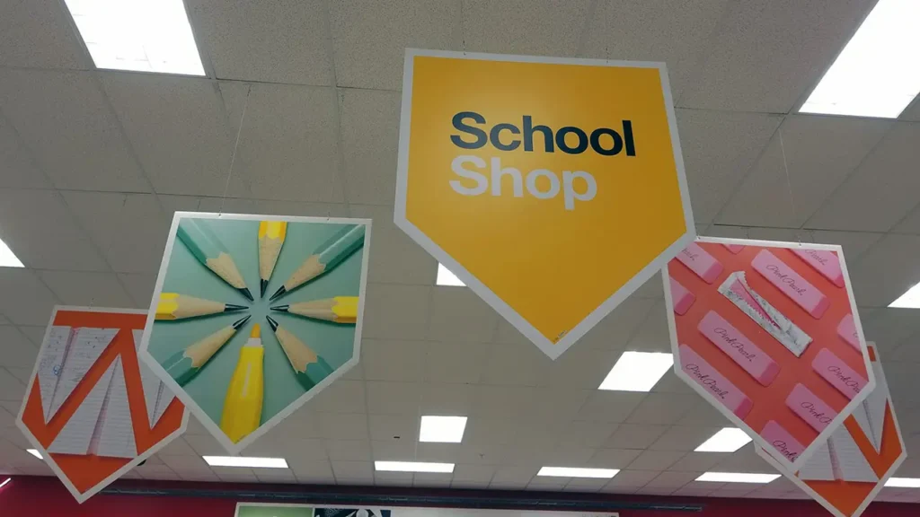 Cartelería aérea suspendida con iluminación LED en pasillo de supermercado