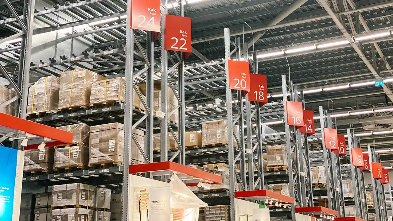 Señalética de seguridad para centros logísticos de gran formato instalada en los pasillos de un almacén industrial.