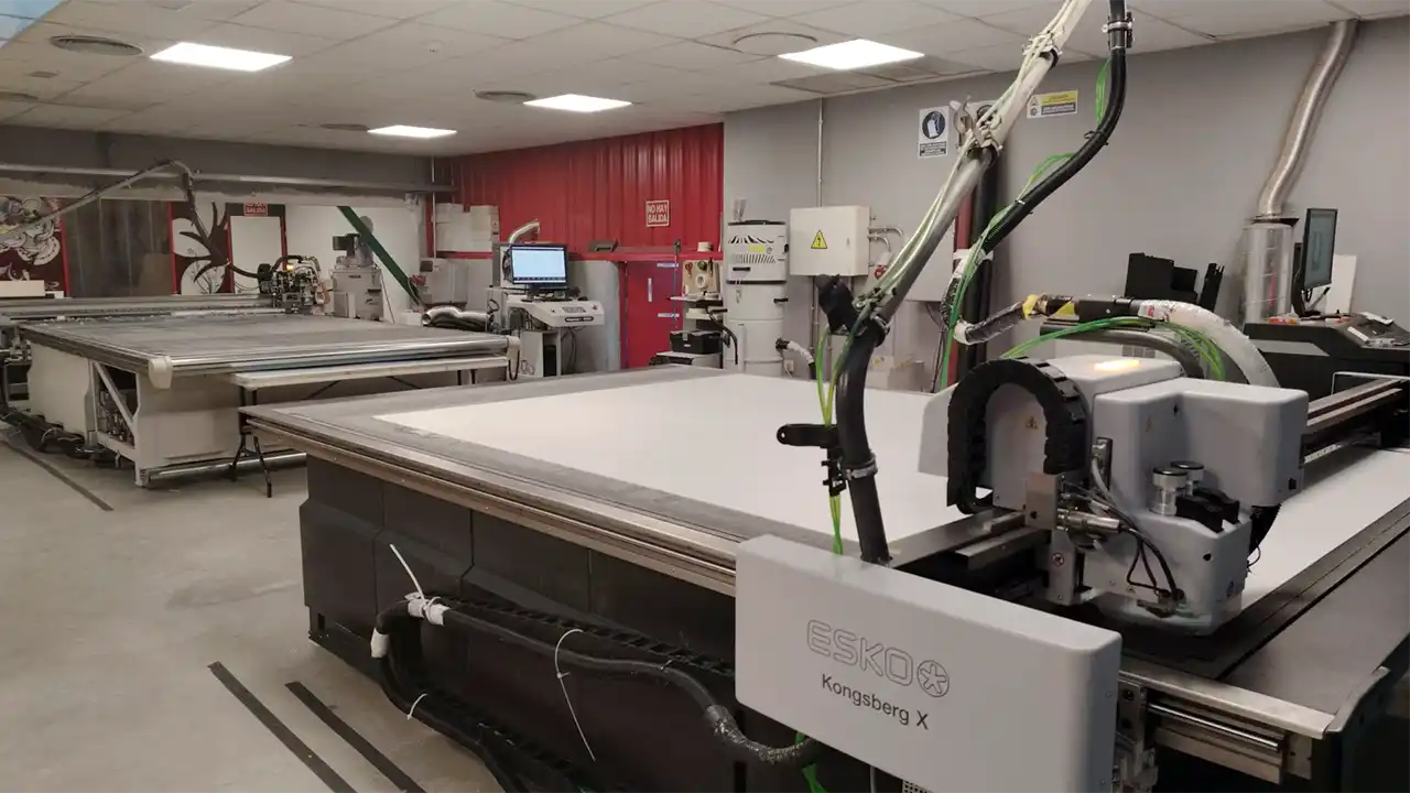 Cabezal de mesa de corte digital realizando fresado y corte en V para packaging rígido industrial